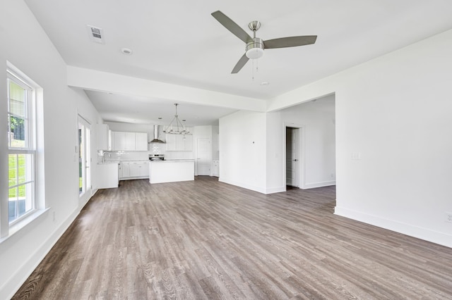 unfurnished living room with ceiling fan and dark hardwood / wood-style flooring