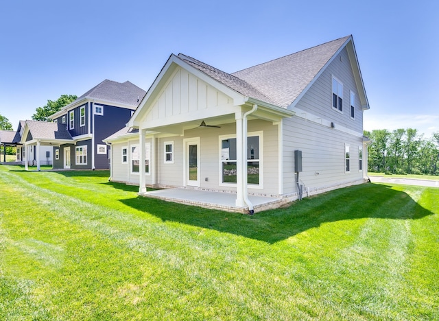 back of house featuring a lawn, ceiling fan, and a patio area