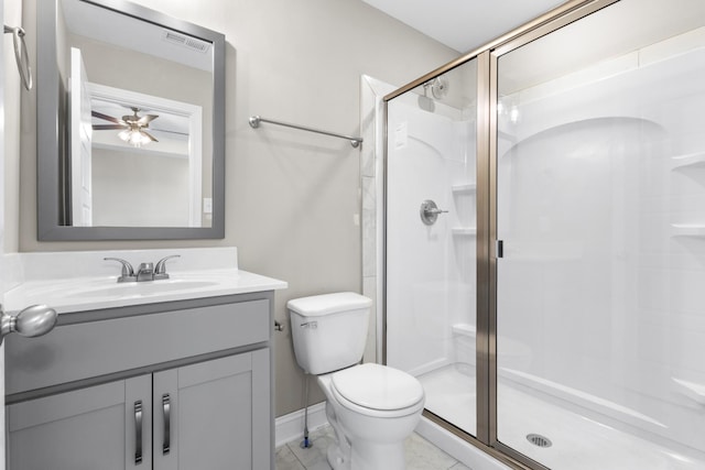 bathroom with toilet, vanity, ceiling fan, and a shower with shower door