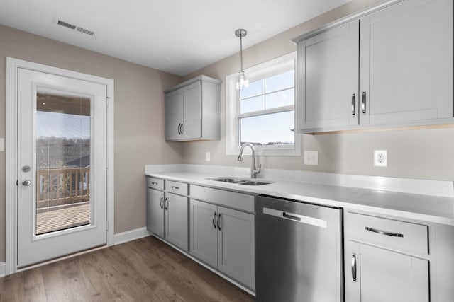 kitchen featuring sink, stainless steel dishwasher, dark hardwood / wood-style floors, pendant lighting, and gray cabinetry