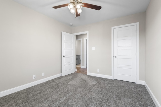 unfurnished bedroom featuring dark carpet and ceiling fan