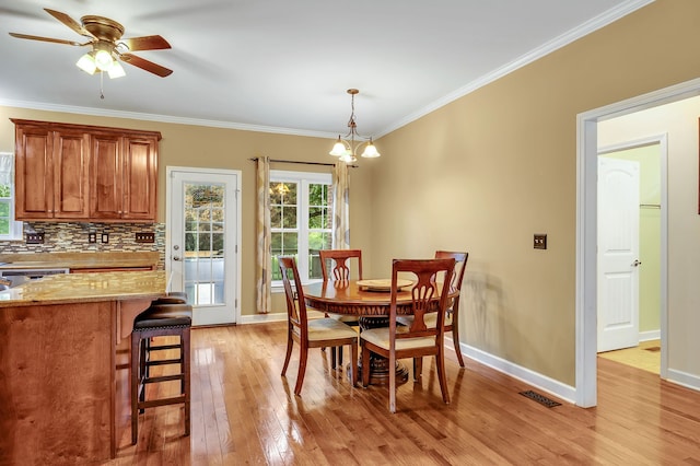 dining space with ornamental molding, light hardwood / wood-style floors, and ceiling fan with notable chandelier