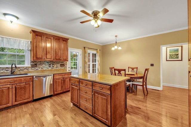 kitchen with pendant lighting, sink, stainless steel dishwasher, tasteful backsplash, and light hardwood / wood-style floors