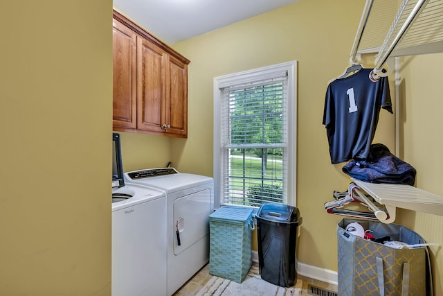 washroom featuring cabinets, light tile flooring, and washer and dryer