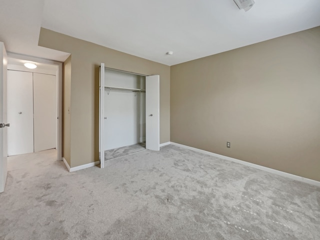 unfurnished bedroom featuring a closet and light carpet