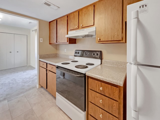 kitchen with white appliances and light tile floors