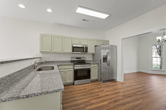 kitchen with sink, green cabinets, dark hardwood / wood-style flooring, stainless steel appliances, and light stone counters