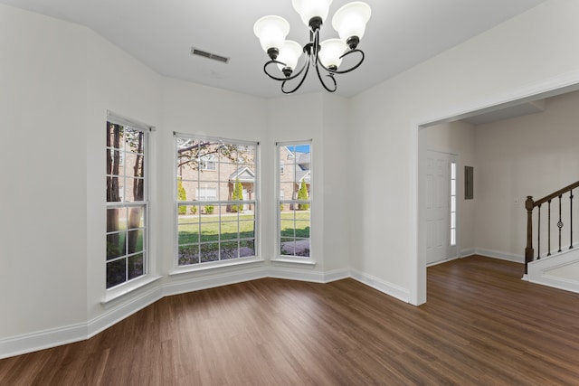 unfurnished dining area featuring dark wood-type flooring and a notable chandelier