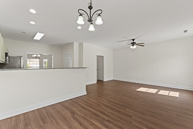 unfurnished living room featuring dark wood-type flooring and ceiling fan with notable chandelier