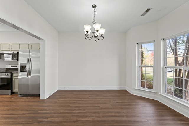 unfurnished dining area with a notable chandelier and dark hardwood / wood-style floors