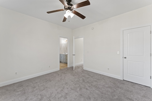 unfurnished bedroom featuring connected bathroom, light carpet, and ceiling fan