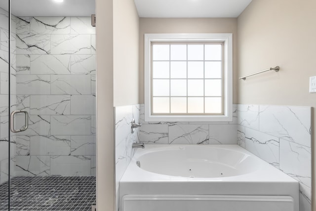 bathroom featuring tile walls and independent shower and bath