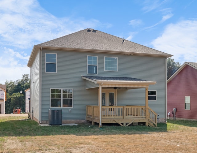 rear view of property featuring central AC, a deck, and a lawn