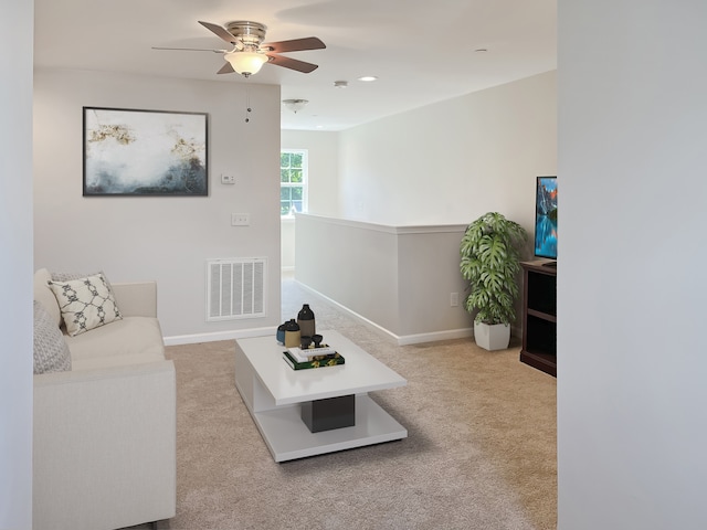 carpeted living room with ceiling fan