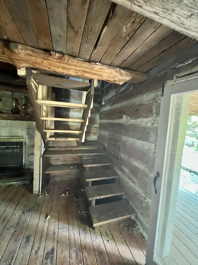 staircase featuring wood walls, wooden ceiling, and hardwood / wood-style flooring