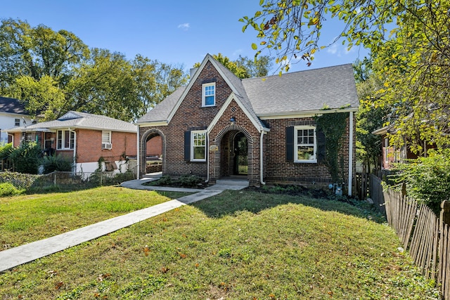 tudor home featuring a front lawn