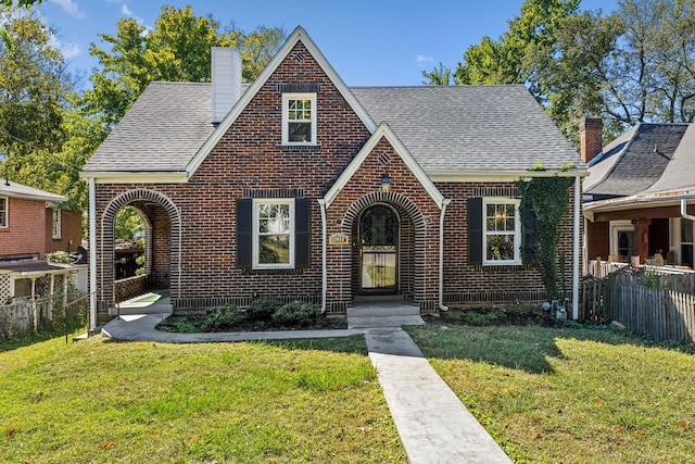 tudor home with a front lawn