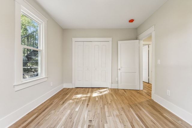 unfurnished bedroom featuring a closet and light hardwood / wood-style floors