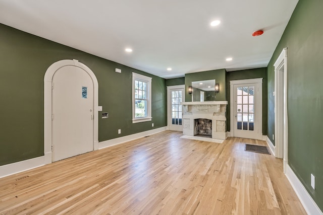 unfurnished living room with light hardwood / wood-style floors and plenty of natural light