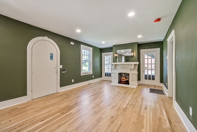 unfurnished living room with a healthy amount of sunlight and light wood-type flooring