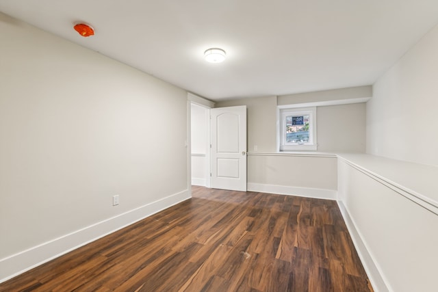 unfurnished room with dark wood-type flooring