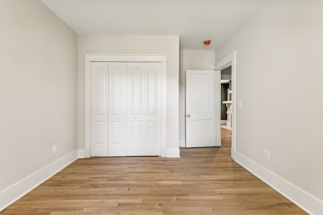 unfurnished bedroom featuring light hardwood / wood-style flooring and a closet