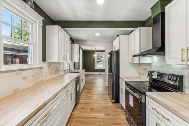 kitchen with wooden counters, black appliances, and white cabinetry