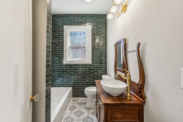 bathroom featuring vanity, a tub to relax in, toilet, and tile walls