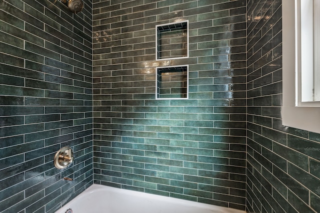 bathroom featuring tiled shower / bath