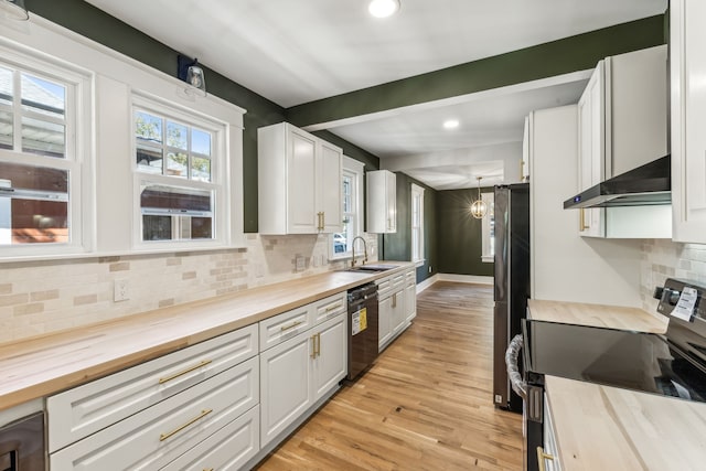 kitchen with stainless steel appliances, extractor fan, wooden counters, and white cabinets