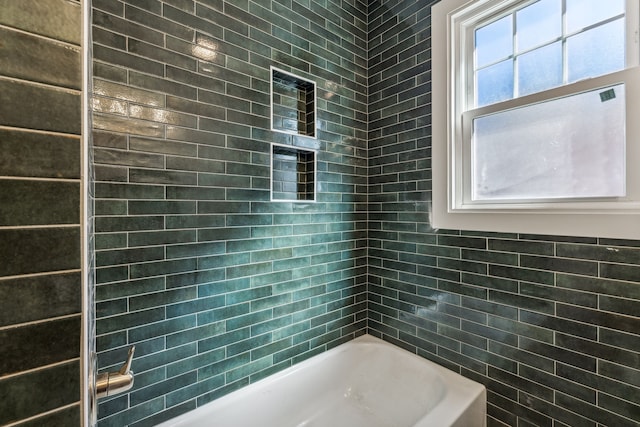 bathroom featuring tiled shower / bath combo and tile walls