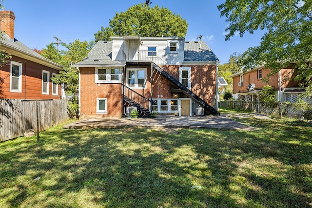 rear view of property with a patio and a lawn