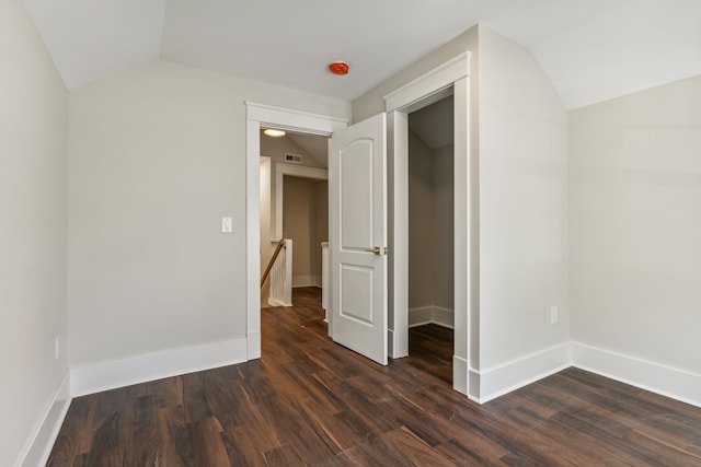 unfurnished bedroom featuring dark wood-type flooring and vaulted ceiling