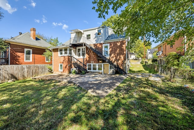 back of house with a yard and a patio