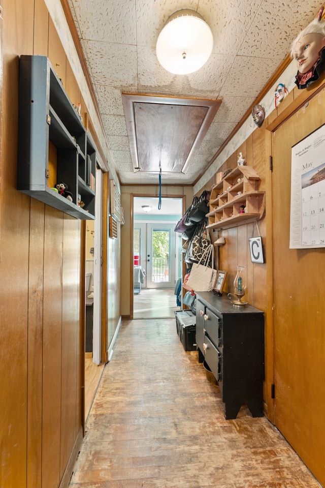 hall with wood walls and light hardwood / wood-style flooring