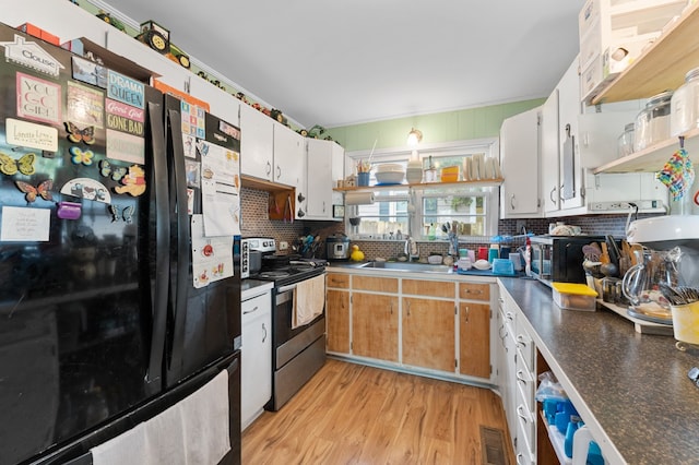 kitchen featuring light hardwood / wood-style flooring, tasteful backsplash, stainless steel electric range, black refrigerator, and white cabinets