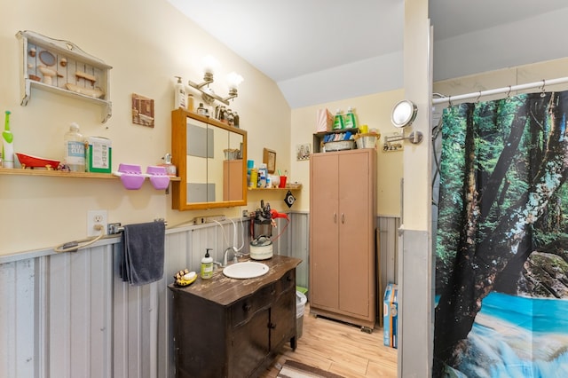 bathroom featuring lofted ceiling, vanity, and hardwood / wood-style floors