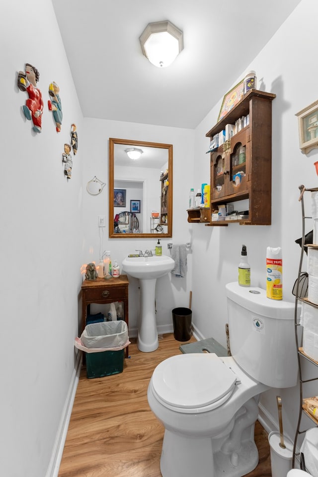 bathroom featuring wood-type flooring and toilet