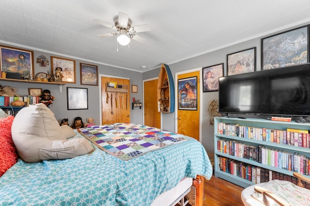 bedroom with crown molding, hardwood / wood-style flooring, and ceiling fan