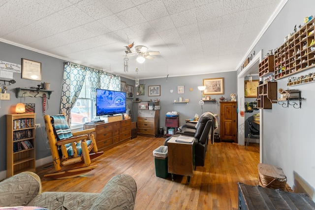 living room featuring ceiling fan, ornamental molding, and hardwood / wood-style flooring