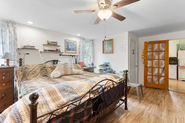 bedroom featuring ceiling fan, light hardwood / wood-style floors, and refrigerator