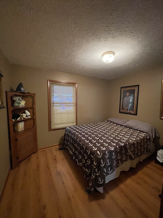 bedroom featuring hardwood / wood-style floors and a textured ceiling