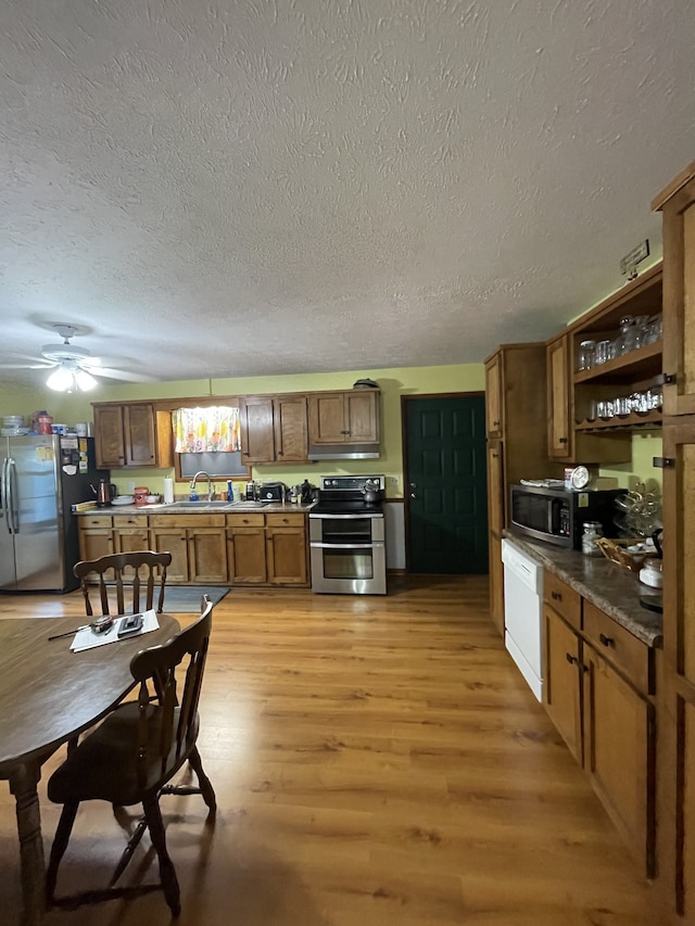 kitchen featuring appliances with stainless steel finishes, ceiling fan, light hardwood / wood-style floors, and a textured ceiling