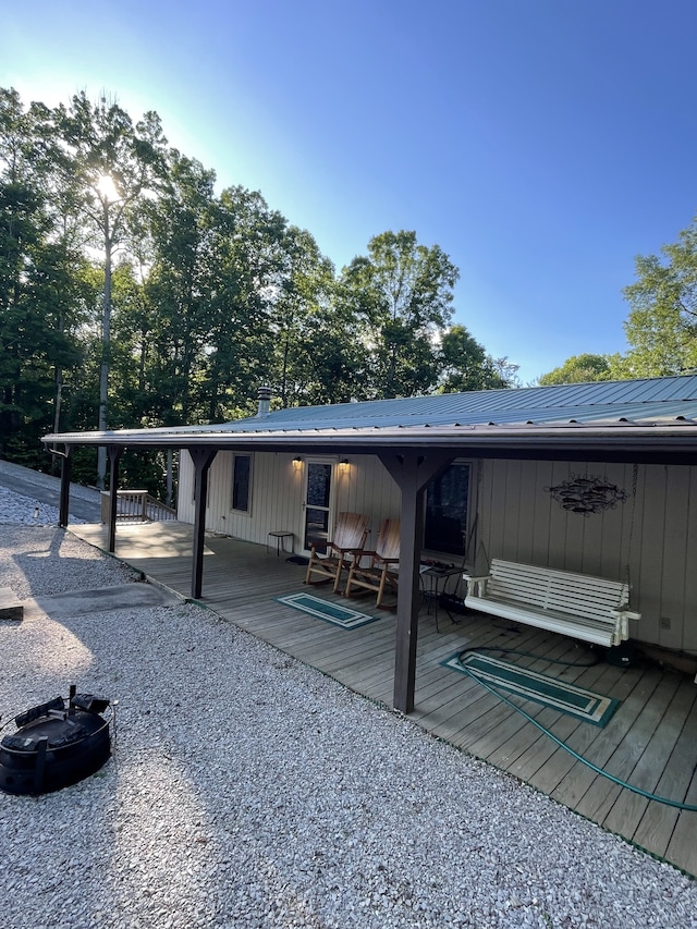 exterior space featuring an outdoor fire pit and a deck