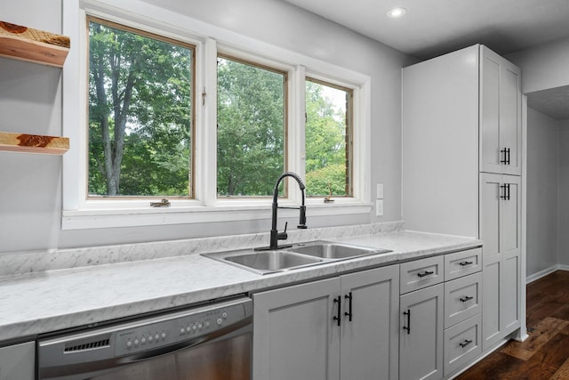 kitchen with dishwasher, dark hardwood / wood-style flooring, sink, white cabinets, and light stone counters