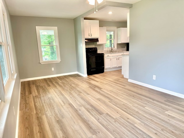 unfurnished living room featuring sink and light wood-type flooring