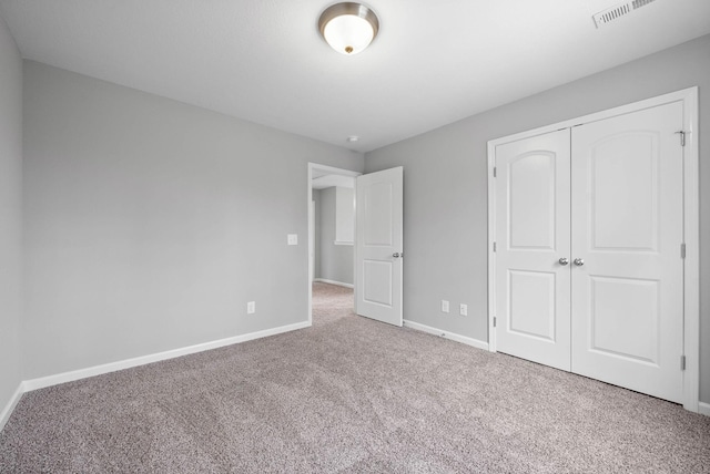 unfurnished bedroom with a closet, visible vents, baseboards, and carpet