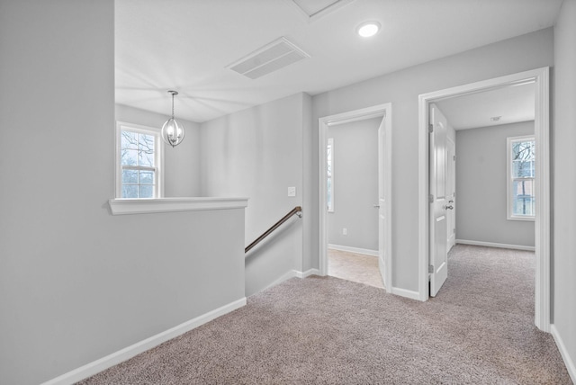 spare room with visible vents, a healthy amount of sunlight, baseboards, and carpet floors