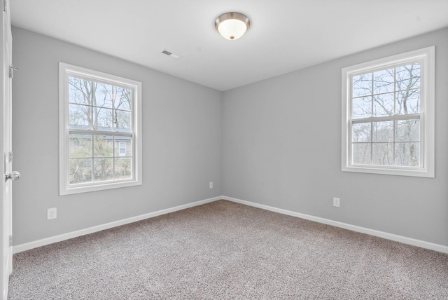 carpeted empty room with visible vents and baseboards