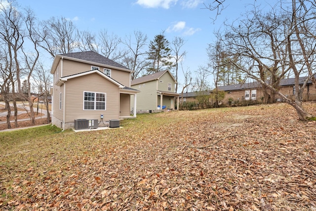 back of house with a yard and central AC